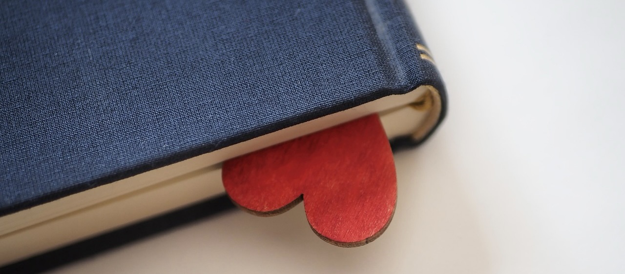 a book with a red felt heart bookmark