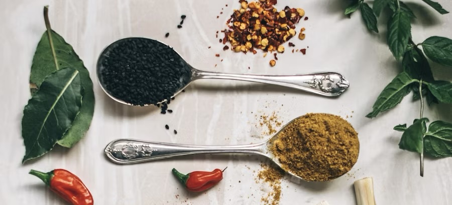scattered herbs and ground spices in spoons