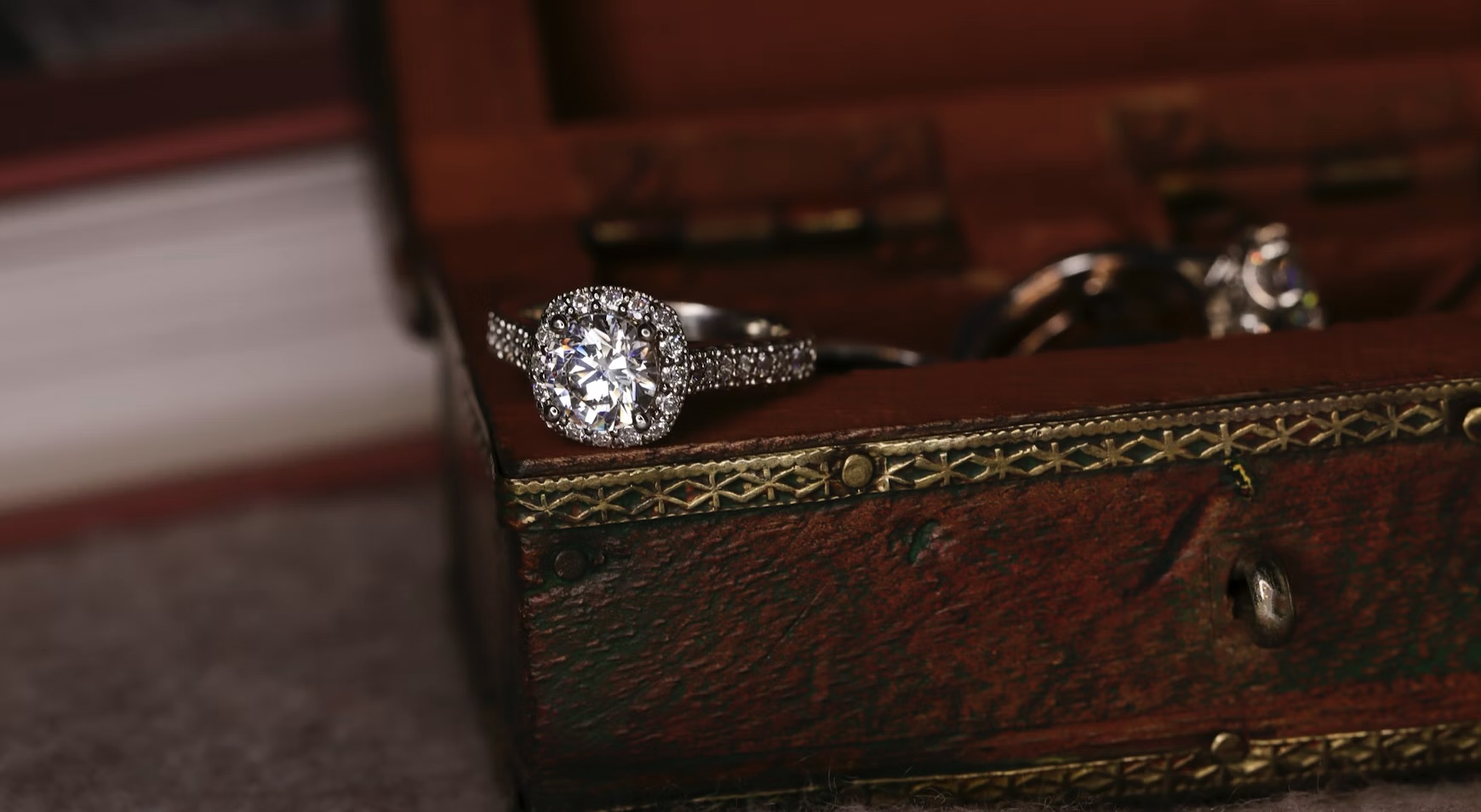an old wooden jewelry box with a ring and assorted jewelry